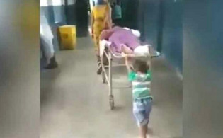 মাত্র ৬ বছরের শিশু হাসপাতালে অসুস্থ দাদুর স্ট্রেচার ঠেলছে
